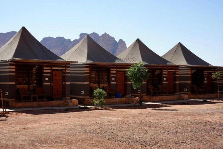 A row of pyramid-shaped buildings with a desert landscape and mountains in the background. 2