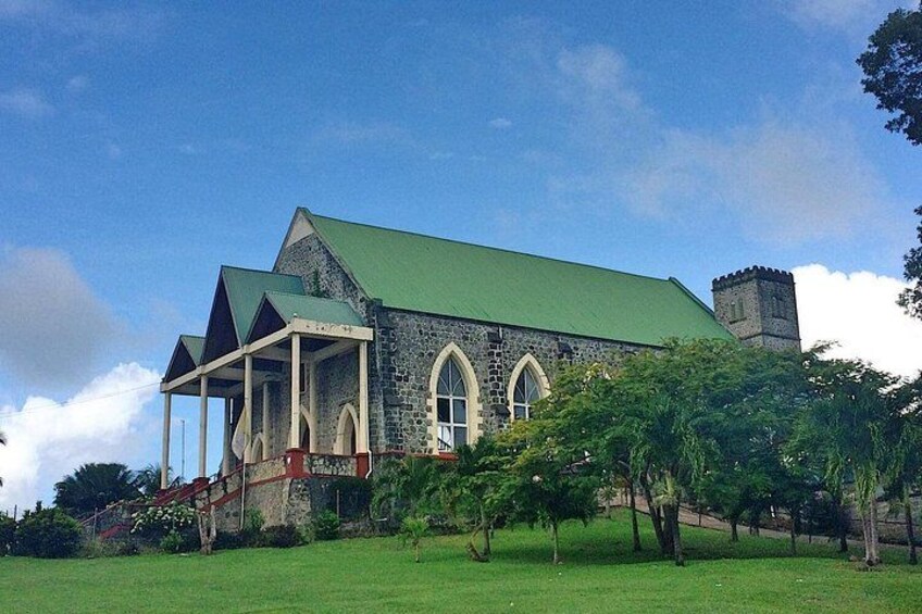 A stone church with a green roof and a tower. 4