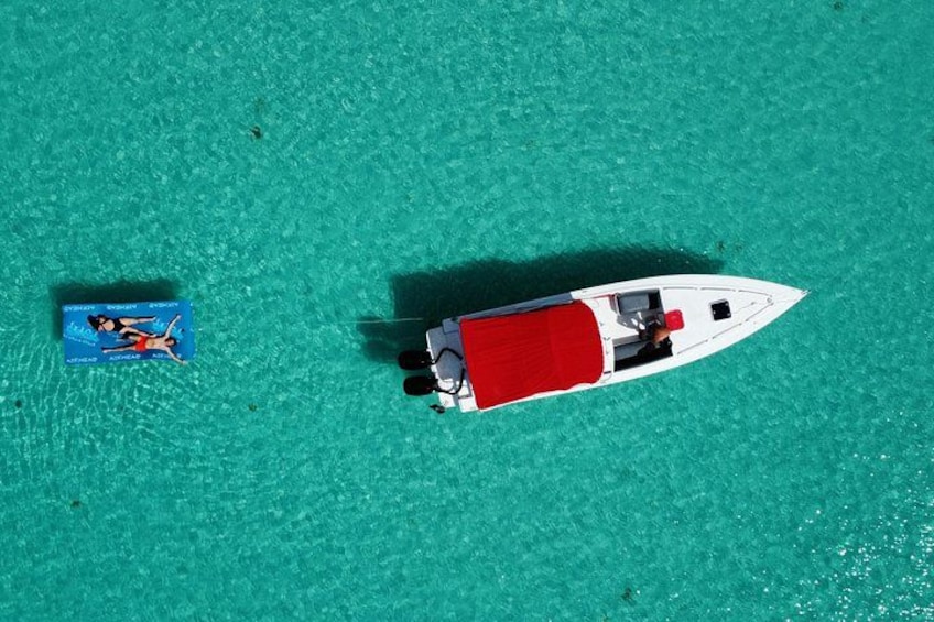 Ein weißes Boot mit einem roten Verdeck auf türkisfarbenem Wasser. 2