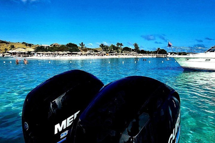 Mar azul y despejado, un bote y una playa con sombrillas. 4