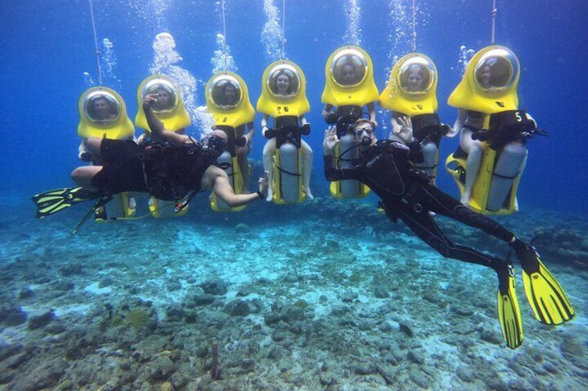 Un groupe de plongeurs, portant des casques jaunes et des combinaisons de plongée noires, se trouve sous l’eau. 4