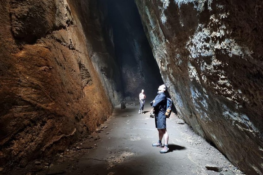 A narrow canyon with rocky walls and a person standing in the middle. 5