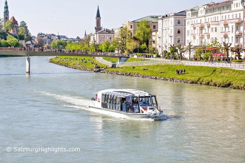 Een riviercruiseschip vaart over een rivier, met een stadsgezicht op de achtergrond. 2