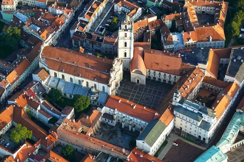 Vista aérea de un pueblo histórico con una iglesia destacada, una plaza central y edificios circundantes. 3