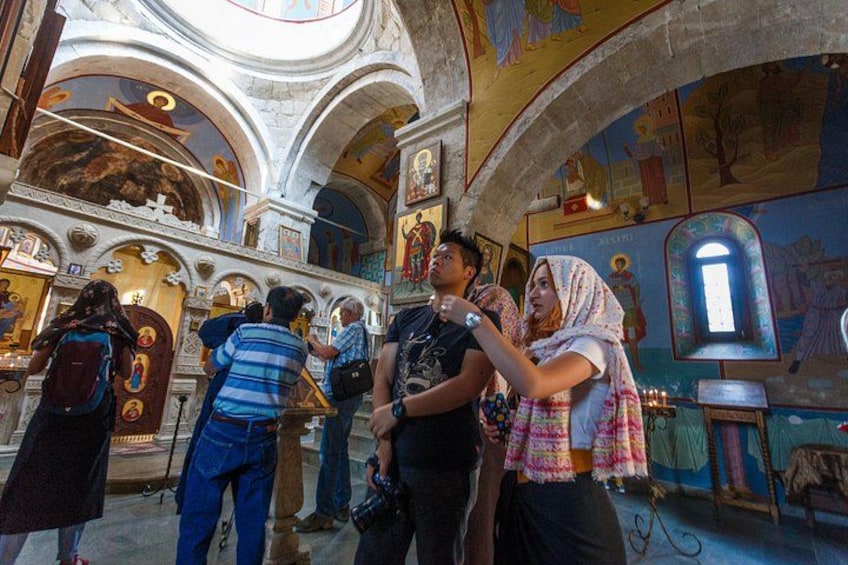 L’intérieur d’une église, avec des voûtes en arc, des icônes religieuses et un groupe de personnes. 2