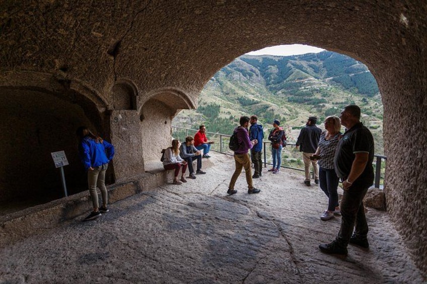 A group of people standing in a stone archway overlooking a valley. 3