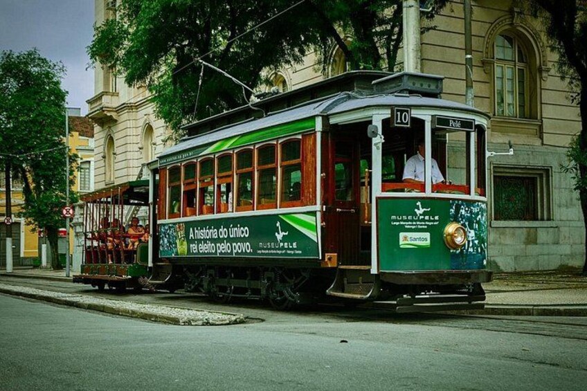 A green and white tram with a number 10 sign, parked on a street with a building in the background. 4
