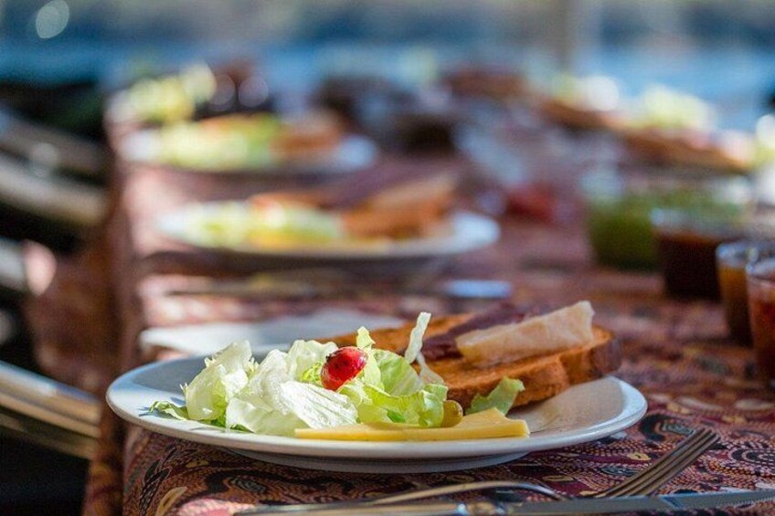 A dining table with plates of food, including a salad and bread. 2