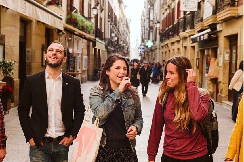 A group of people walking on a street with buildings on both sides. 3