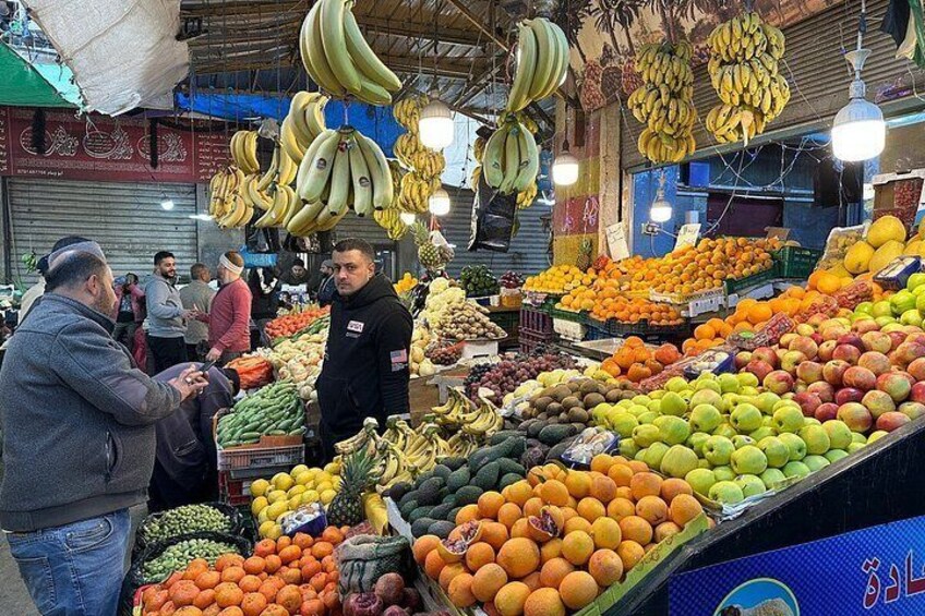 Un marché aux fruits où l’on peut voir une variété de fruits exposés et où les gens font leurs achats. 5