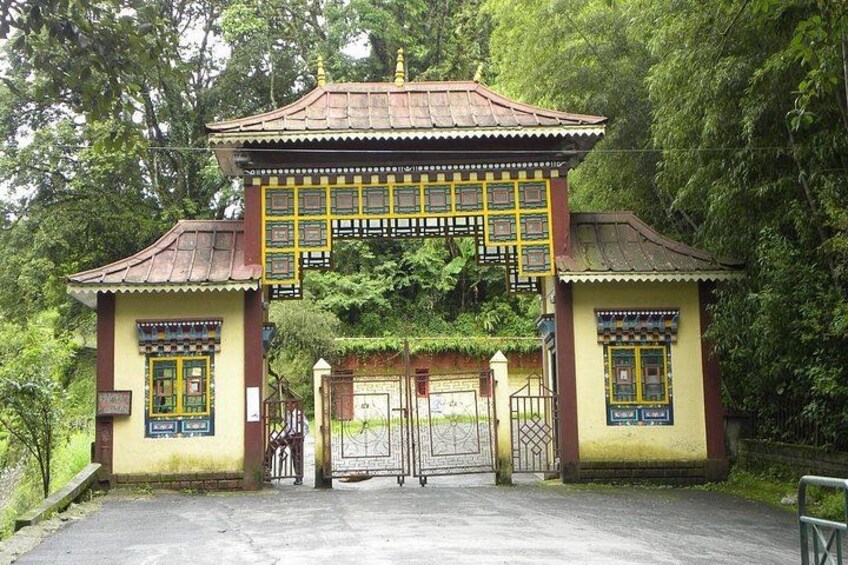 A traditional gate with a tiled roof, surrounded by lush greenery. 4