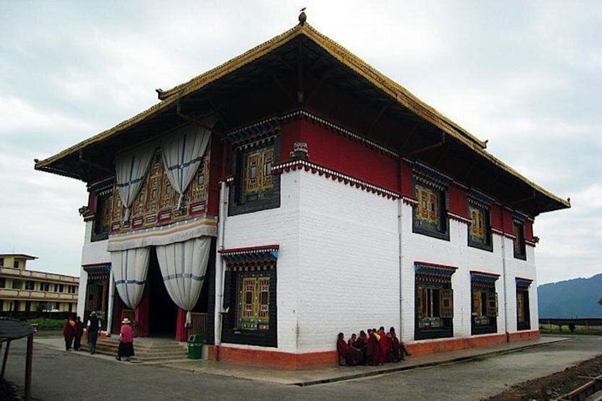 A traditional building with a white facade, red and gold trim, and a peaked roof. 5