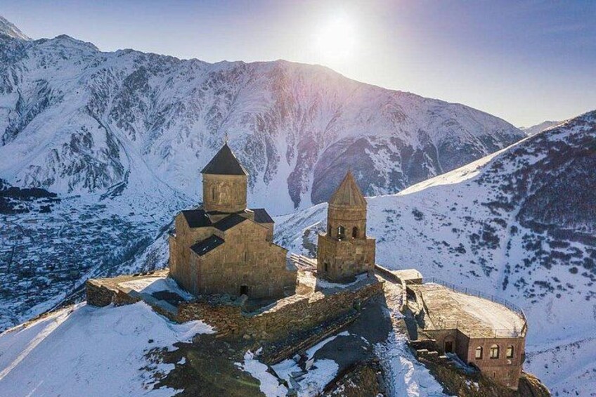 Et sneklædt bjerglandskab med kirke og kirketårn. 1