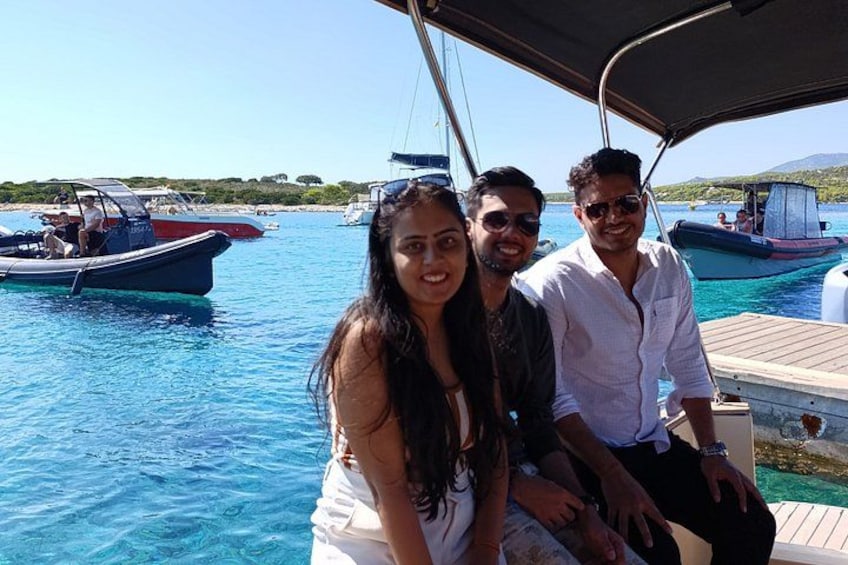 Un groupe de personnes se trouve sur un bateau, avec une eau d’un bleu cristallin et d’autres bateaux en arrière-plan. 2