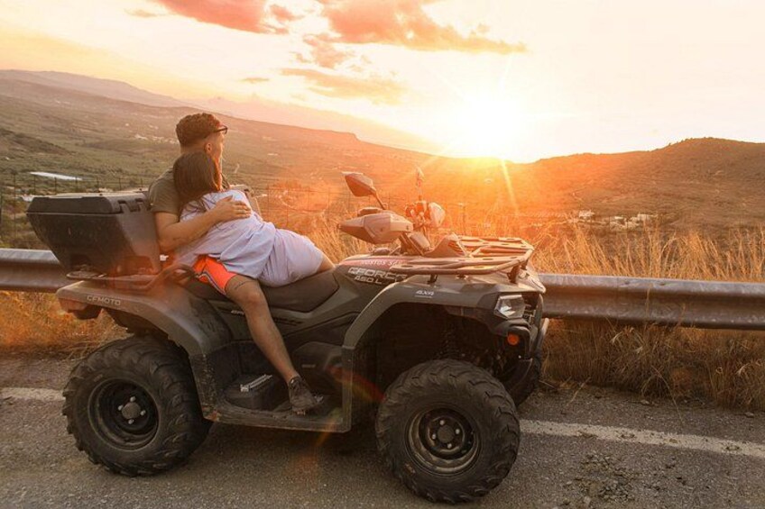 Una persona conduce un cuatrimoto por una carretera con un atardecer de fondo. 5