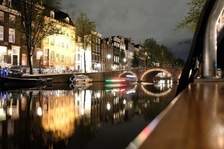 Un canal con edificios reflejados en el agua, un puente y una bicicleta en primer plano. 3