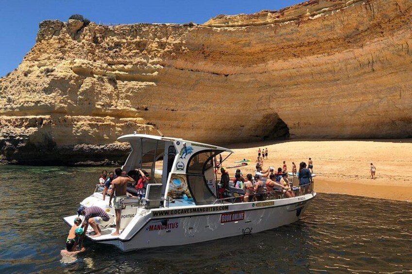Una barca con persone su una spiaggia rocciosa. 2