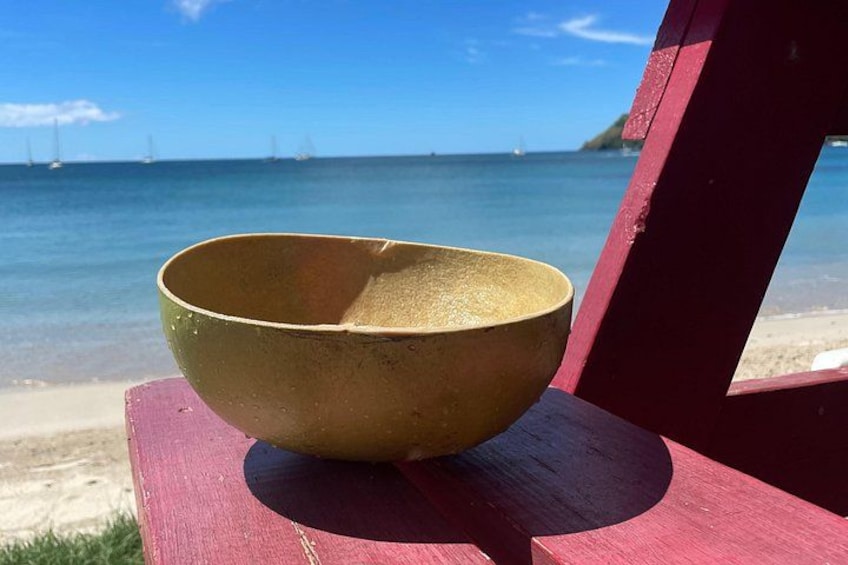 A bowl on a red chair by a beach with sailboats in the background. 1