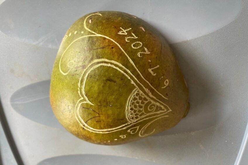 A green stone with white carvings and numbers. 3