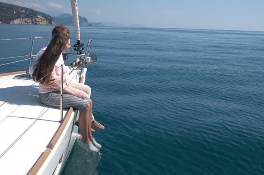 A person sitting on a sailboat's deck, overlooking a calm sea. 2
