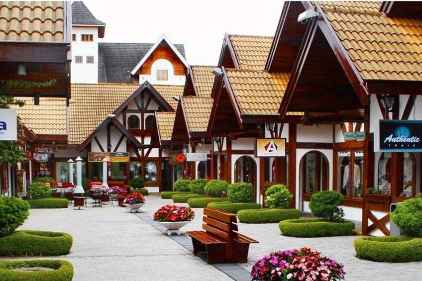 A traditional European village with timber-framed buildings, a cobblestone street, and well-maintained flower beds. 3