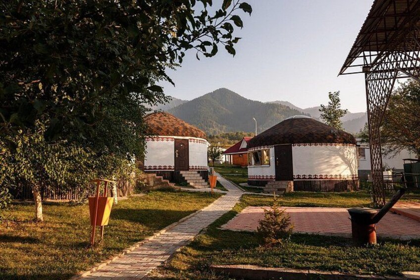Yurts, a pathway, and a mountainous landscape. 1