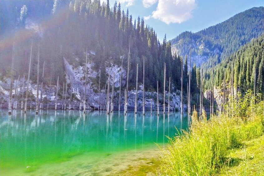 A turquoise lake surrounded by snow-covered trees and a mountainous landscape. 1