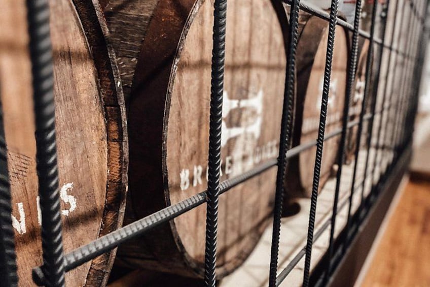Wooden barrels stacked in a metal rack. 3