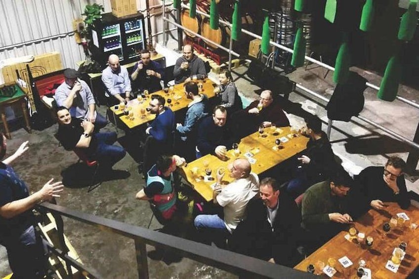 A group of people seated at tables in an indoor setting, possibly a restaurant or meeting area. 3