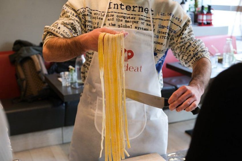 A person making pasta with a knife. 2