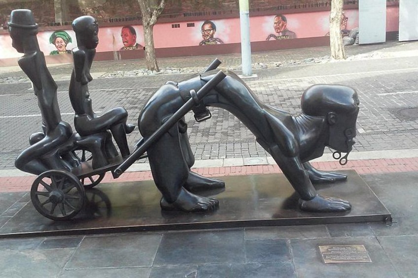 En skulptur af tre personer på en bænk. 4