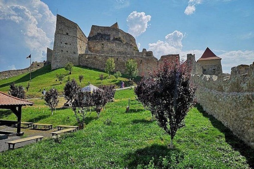 A historic stone castle on a hill with a clear sky. 5