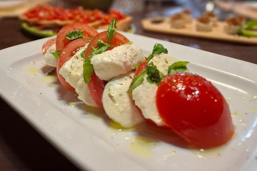 Ein Teller mit Caprese-Salat, bestehend aus Tomaten, Mozzarella und Basilikum. 2