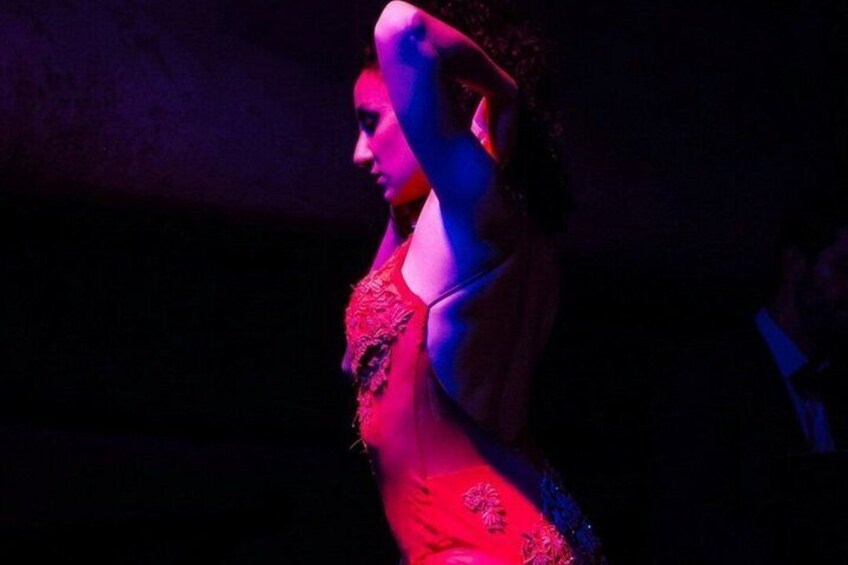 A person in a dimly lit environment with a focus on their upper body and a red garment. 4