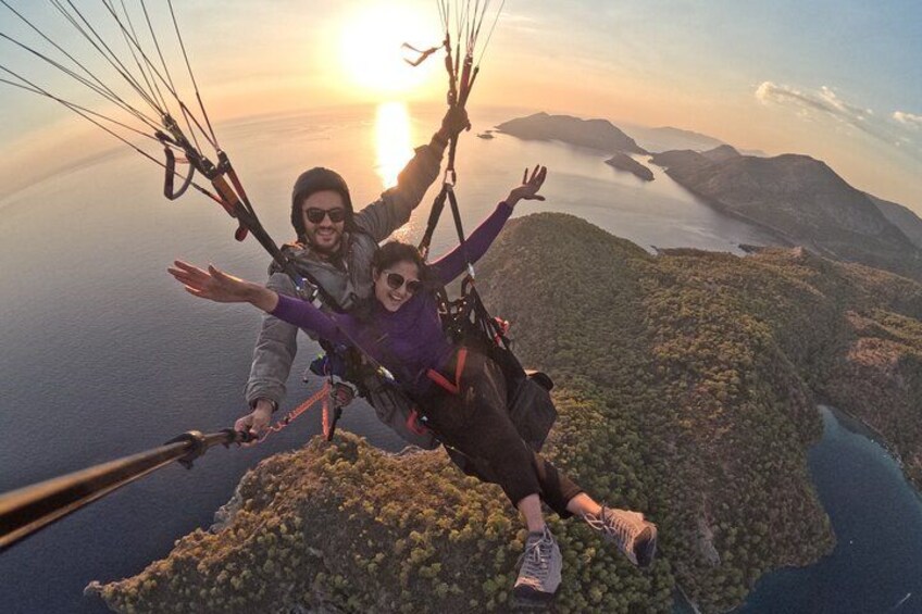 Twee mensen paragliden met een zonsondergang op de achtergrond. 3