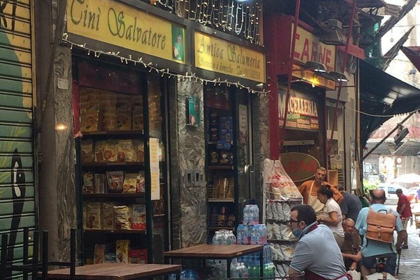 Et gades marked med butikker, heriblandt en butik der hedder 'Cini Salvatore'. 3