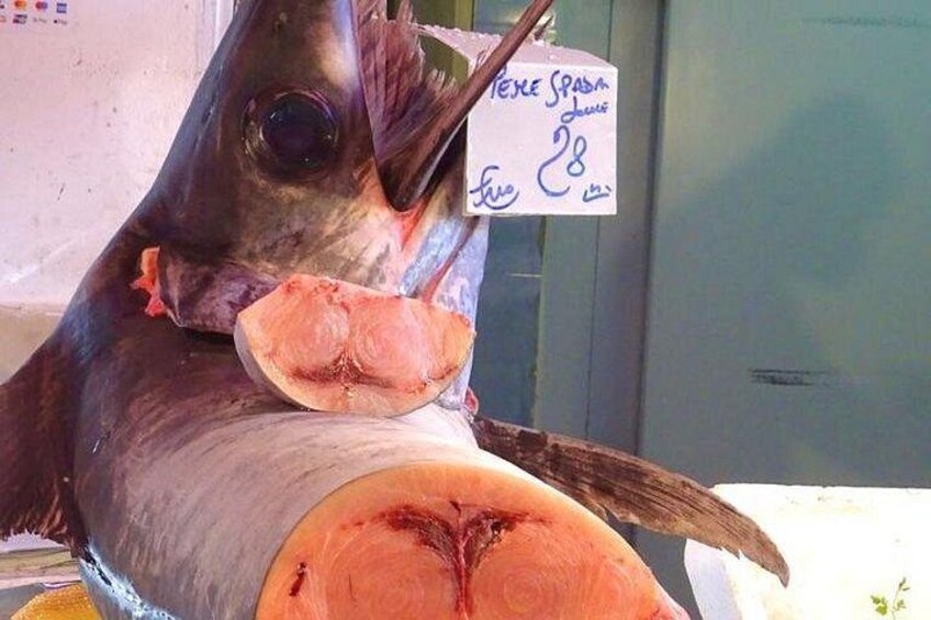 En stor fisk med en mærkat, der angiver 'Pesce Spada' og en pris på 28. 5
