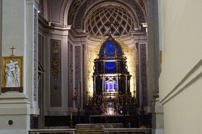 Interior de una iglesia ornamentada con un altar central, una gran cúpula y elaboradas decoraciones en las paredes. 4