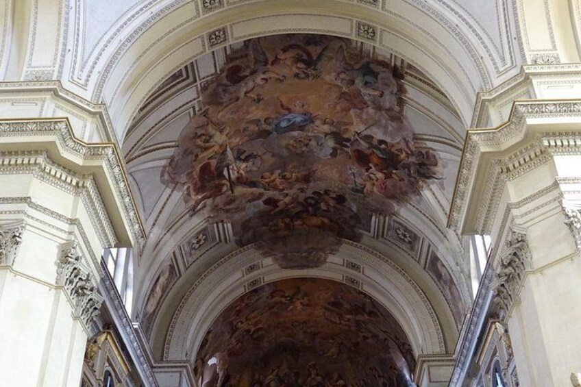 Un techo ornamentado con frescos intrincados y detalles arquitectónicos. 5