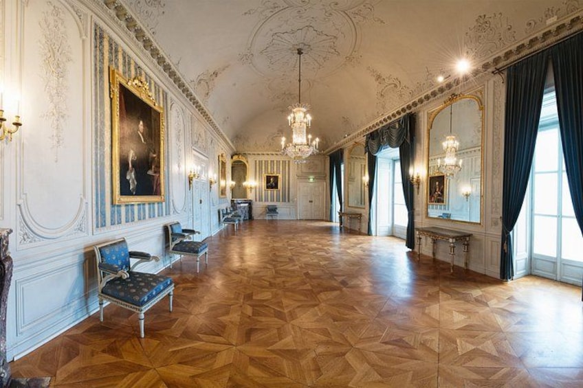 A grand hall with ornate decorations, chandeliers, and classical furniture. 2