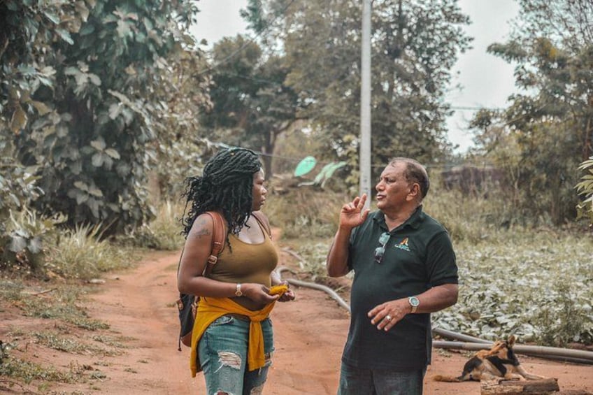 Dos personas conversando en un sendero de tierra rodeado de vegetación. 5
