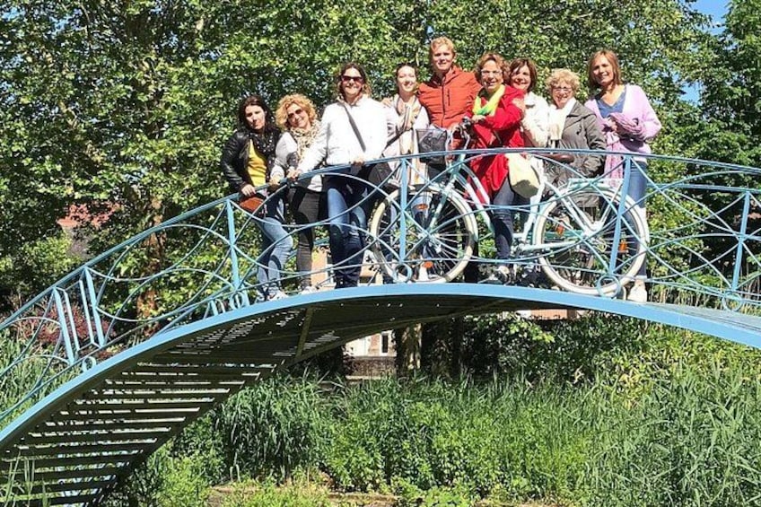 Un grupo de personas en un puente de metal con bicicletas. 3