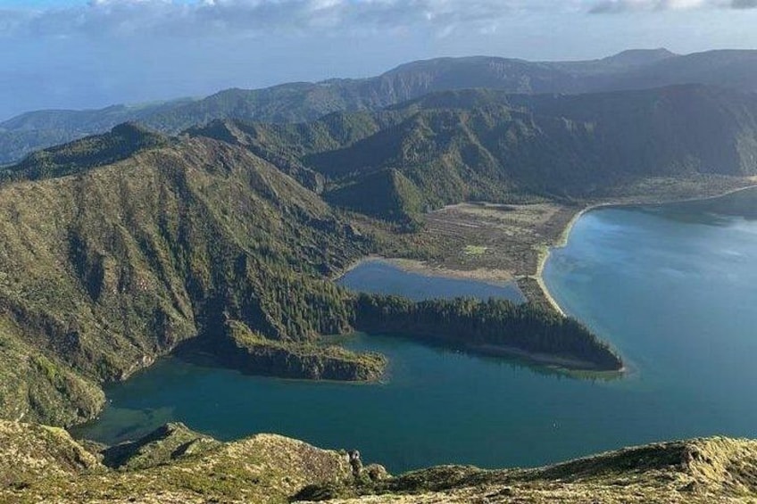 A mountainous landscape with a large lake surrounded by dense forests. 2