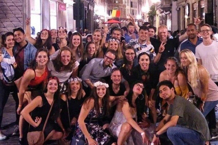 Eine Gruppe von Menschen posiert nachts auf einer Stadtstraße für ein Foto. 4
