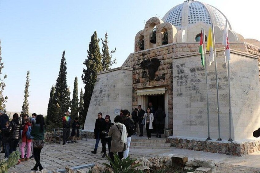 A historical building with a dome and a large eagle relief, surrounded by visitors. 3