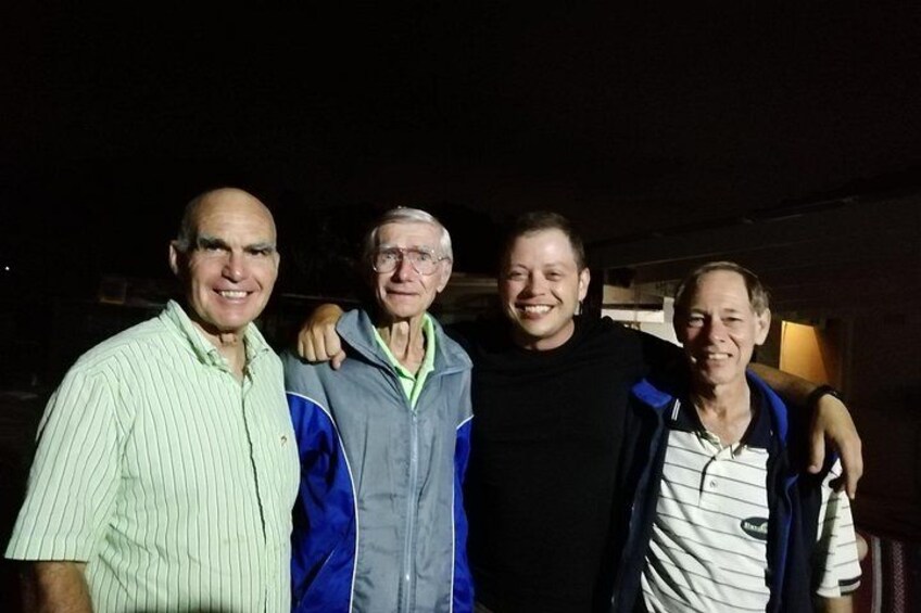 Four men standing together, one with a backpack. 2