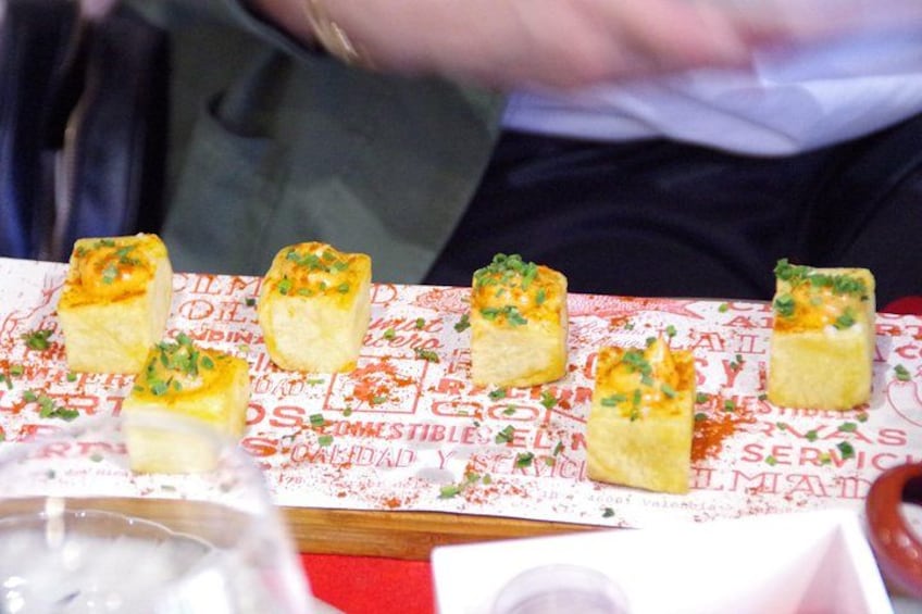 A table with food items, possibly appetizers, garnished with herbs. 4