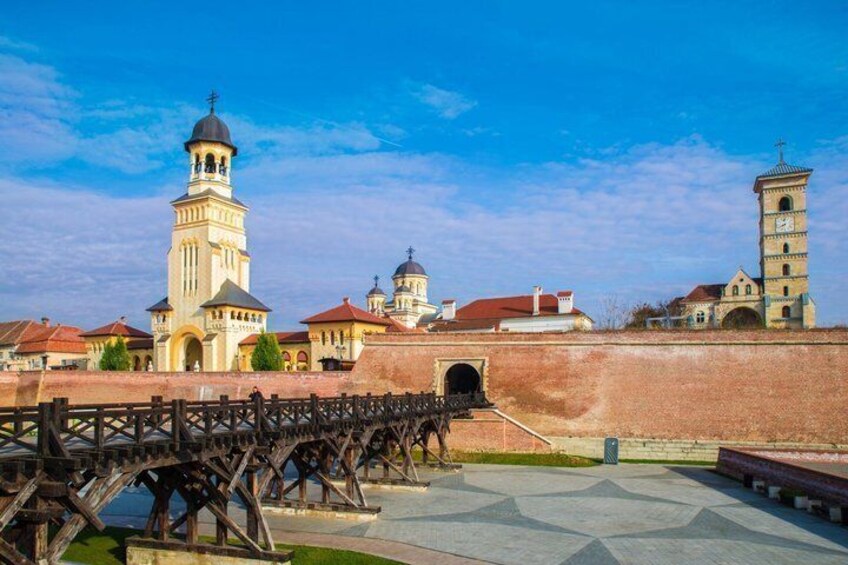 A historic bridge, a church with a bell tower, and a fortress wall. 2