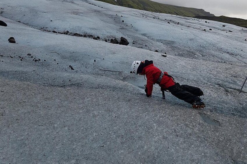 Une personne vêtue d'une veste rouge et d'un casque, sur une pente enneigée. 2