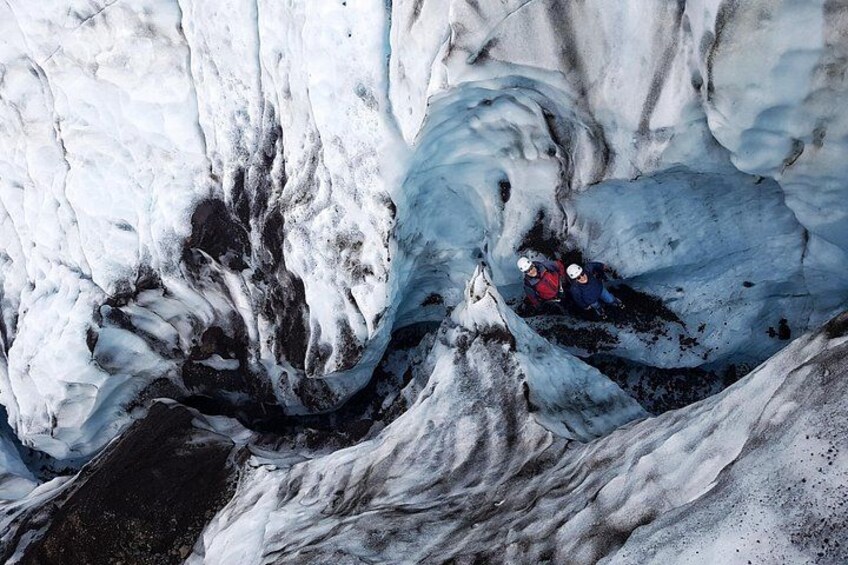 A glacier with crevasses and a person in a crevasse. 2